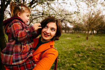 Obraz premium The mother holds on hands her daughter in the park