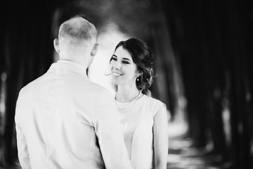 Look from behind groom's shoulder at cheerful brdie smiling to him