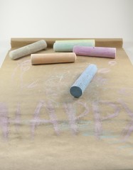 On the photo are colorful crayons and the inscription Happy