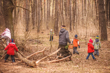 Group of six little kids with a kindergartener running in the forest and climbing trees. Early...