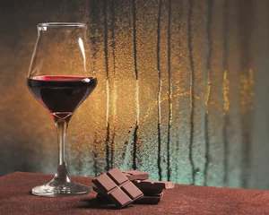 Photo sur Plexiglas Vin Verre à vin rouge avec chocolat et vitre pluvieuse