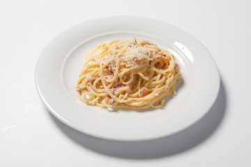Spaghetti Carbonara with bacon and cheese on a white plate