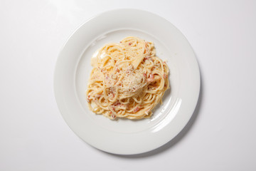 Spaghetti Carbonara with bacon and cheese on a white plate
