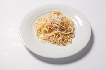 Spaghetti Carbonara with bacon and cheese on a white plate