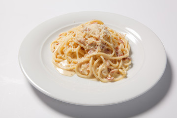 Spaghetti Carbonara with bacon and cheese on a white plate