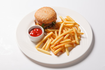 Fast food hamburger and french fries on a white plate