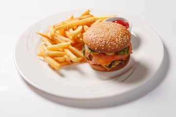 Fast food hamburger and french fries on a white plate
