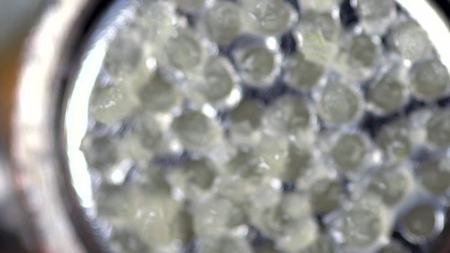 Slow motion macro shot of garlic squeezing out of press