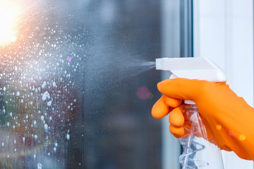 Worker cleans the Windows with spray .