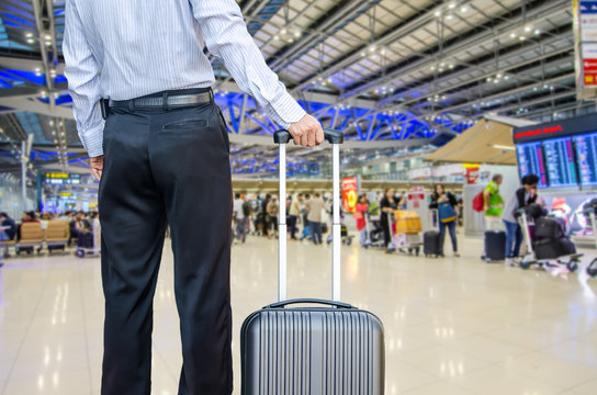 business man walking travel bag by an international airport