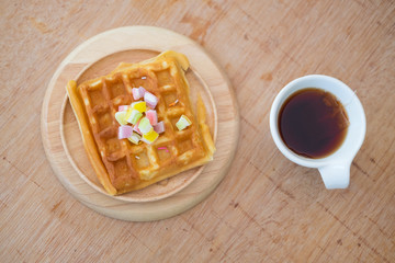 Waffles and hot tea on wood plate