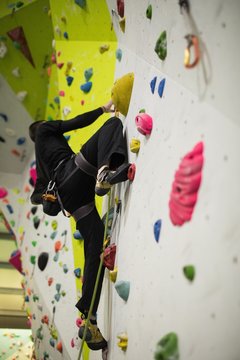 Man practicing rock climbing on artificial climbing wall 