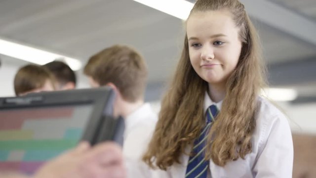 Children in school cafeteria queuing up at electronic till to scan food items