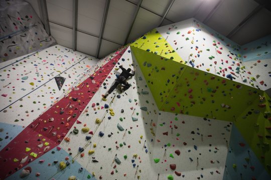 Man practicing rock climbing on artificial climbing wall 