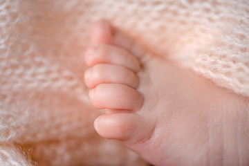 Small newborn legs. Happiness of parents.