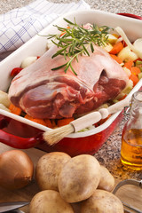 raw leg of lamb with vegetable in a pan
