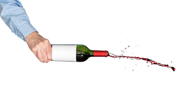 Red wine pouring out of a bottle held by hand