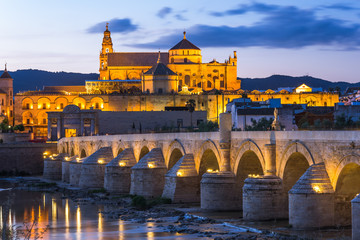 Illuminated Roman Bridge and Mosque-Cathedral at twilight in Cordoba, Spain