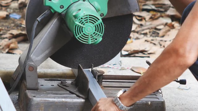 Worker cutting steel by using cutting machine