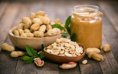 Peanut butter and peanuts on the wooden table