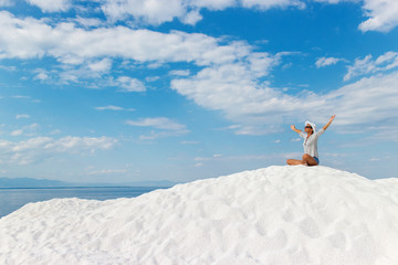 Naklejka na ściany i meble Portrait of young woman sitting on the white beach and meditating.
