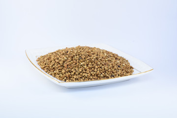 bowl of buckwheat grains on white background