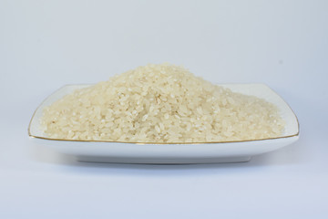 Uncooked dry rice in bowl isolated on white