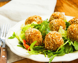 Falafel.Chickpeas balls with sesame and green salad on plate