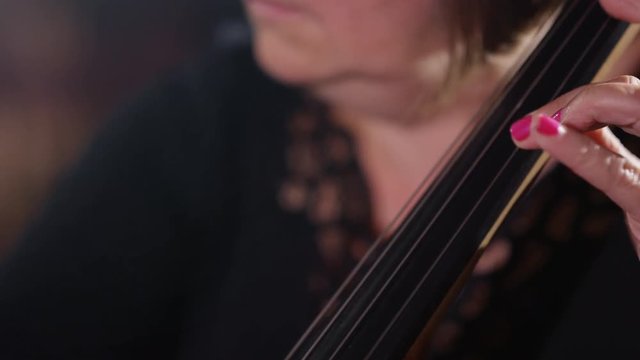  Close up on hands of orchestra cellist during a performance. 