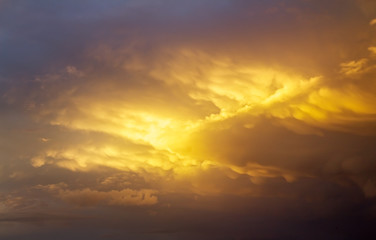 Beautiful dark fluffy cloudy sky with sun rays. Cloudy abstract background. Sunset light.