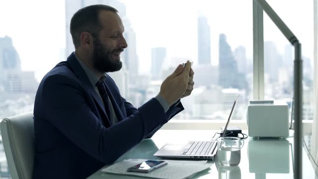 Young businessman with tablet computer sitting by table in the office 4K
