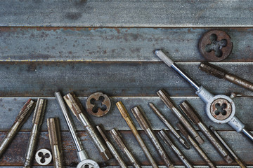 Set of various equipment for threading with copy space, carpenter tool old rusty metal background.