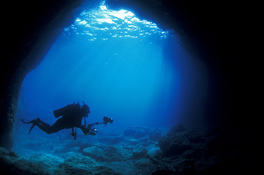 Diver at the enterance of a marine cave, Sarigerme Turkey.