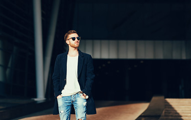 Stylish man with sunglasses and torn jeans. copy space