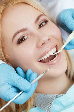 Hollywood smile. Vertical cropped closeup of a beautiful young woman smiling to the camera during dental checkup by her dentist