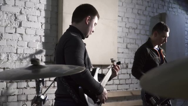 Rehearsal of a rock group, men playing the guitar