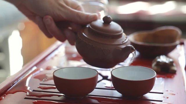 The tea ceremony. Woman pours tea in a tea bowl. Close-up.