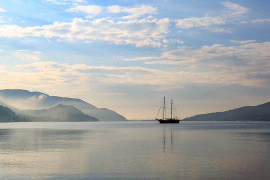 Vintage boat in misty weather with reflection