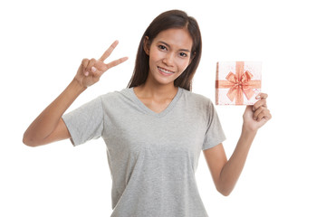 Asian woman show victory sign with a gift box.