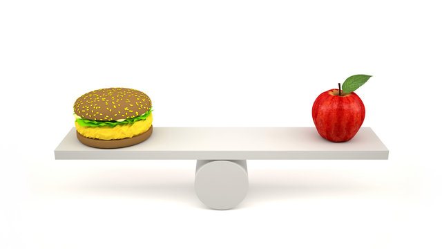 Hamburger and red apple on scales. Balance between fast and healthy food.