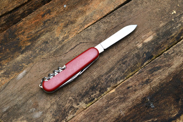 Multipurpose knife isolated on wooden background