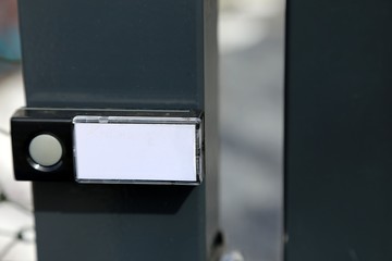 Klingeknopf einer Funkklingel mit leerem Namensschild an Gartentor