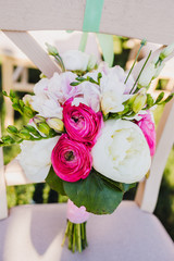 The wedding bouquet stands on the chair