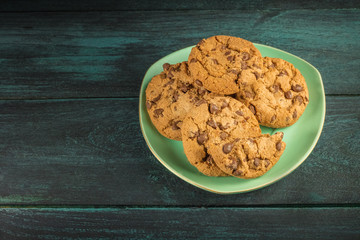 A teal plate of chocolate chips cookies with copyspace