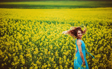 Fototapeta premium The charming girl stands near many flowers