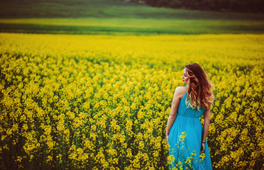 Fototapeta premium The charming girl stands near many flowers