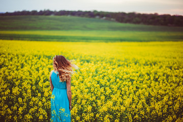 The charming girl stands near many flowers