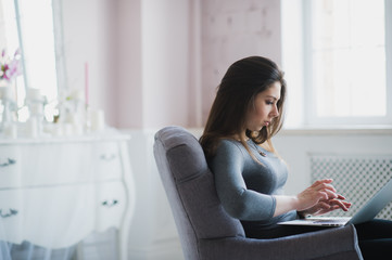 Obraz premium Young attractive woman at home, working with laptop, free online classes for interest, stay-at-home mom starting an online business, internet marketing, remote job, lady- blogger