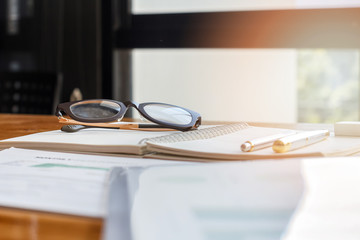 eyeglasses on notebook on window background