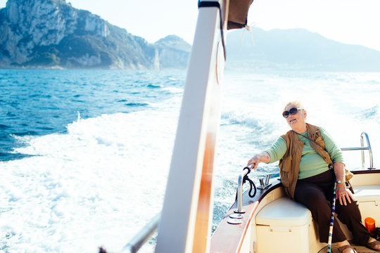 Senior woman enjoying boat ride to Capri, Italy